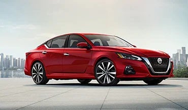 2023 Nissan Altima in red with city in background illustrating last year's 2022 model in Lynn Layton Nissan in Decatur AL