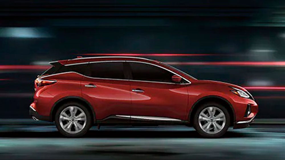 2023 Nissan Murano shown in profile driving down a street at night illustrating performance. | Lynn Layton Nissan in Decatur AL